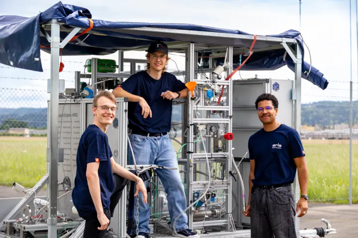 Thomas Ebnöther, Noah Giger and Simi Wespi (left to right) of ARIS Perseus&nbsp;in front of the mobile for the RDRE rocket engine.