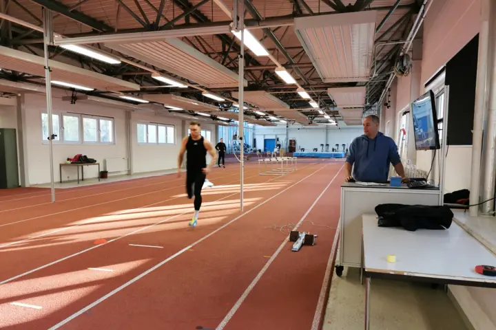 A sprinter runs on a sprint track under which digital force plates are installed.