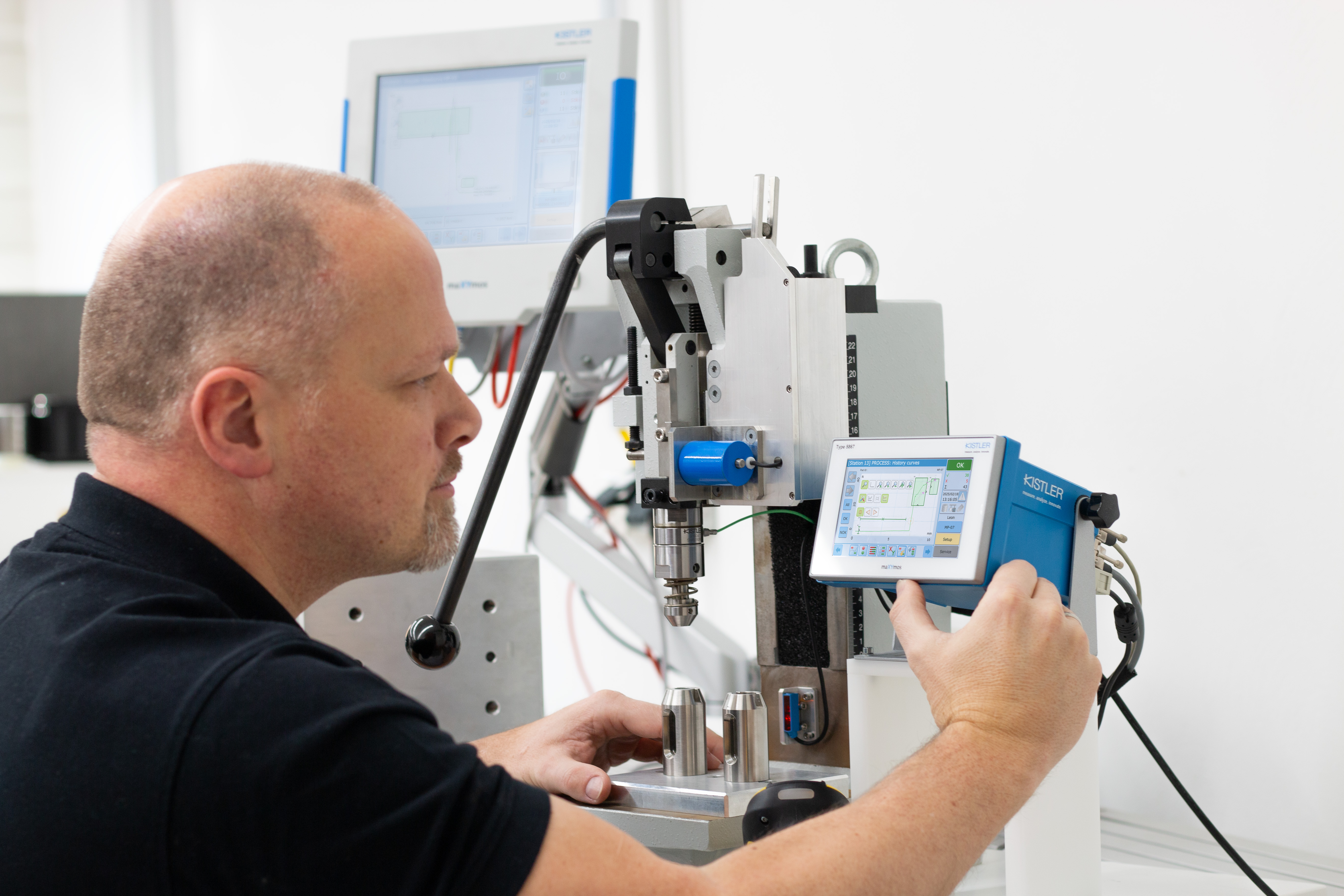 A man is doing force-displacement monitoring with maXYmos BL.